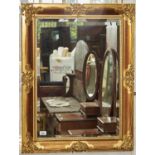 A REPRODUCTION GILT MIRROR, FOLIATE CLASPED, HATCHED FRAME WITH LEAFY SLIP, BEVELLED PLATE, 85 X
