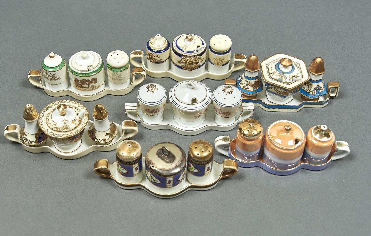 SEVEN NORITAKE CONDIMENT SETS, EARLY 20TH C, EACH ON TWO HANDLED TRAY, ONE WITH IRIDESCENT GLAZE,