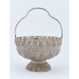 AN INDIAN SILVER REPOUSSE BASKET, LATE 19TH C, WITH PIERCED BORDER AND SWING HANDLE, 16CM DIAM,