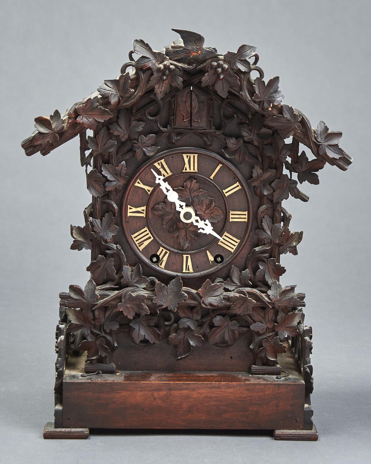 A GERMAN CARVED AND STAINED WOOD CUCKOO CLOCK, LATE 19TH C, OF TYPICAL FORM WITH TILED, PITCHED ROOF