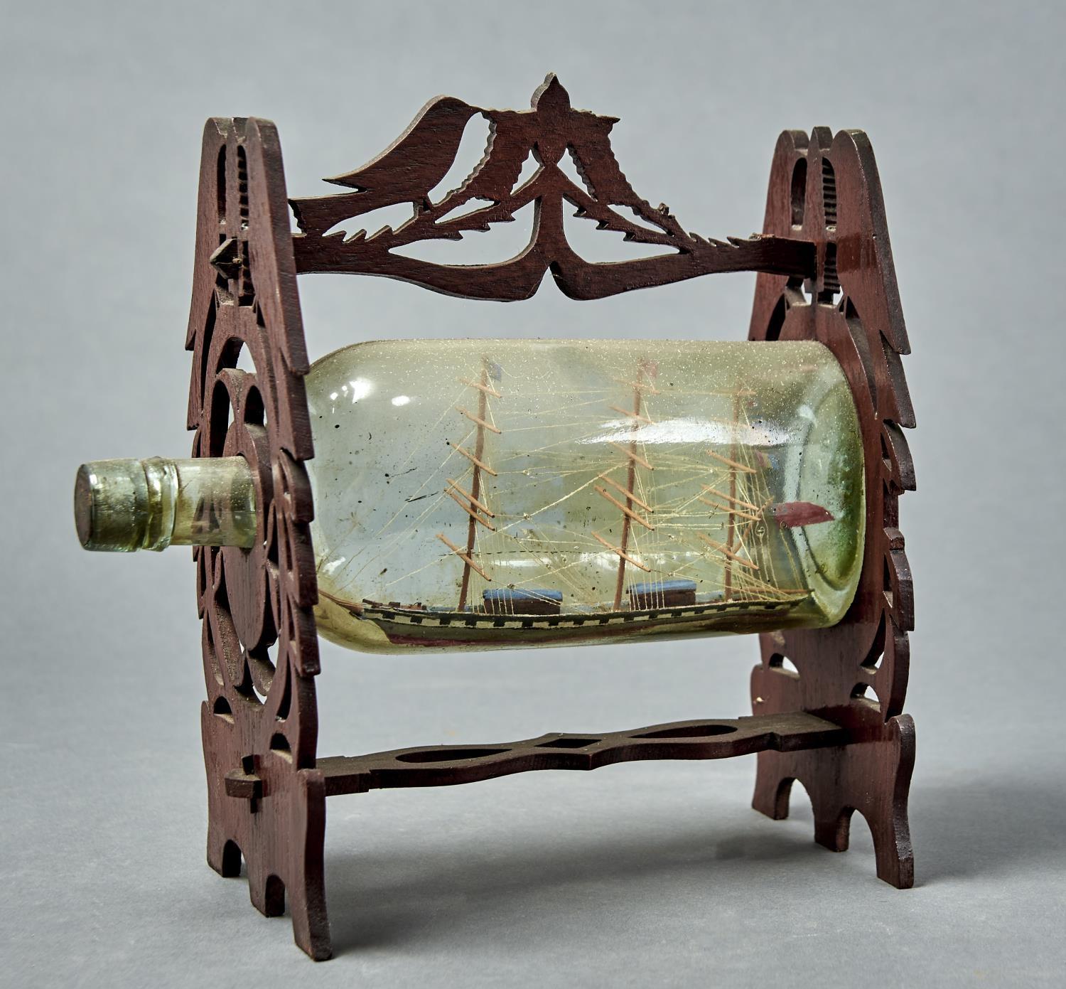 A VINTAGE SHIP IN A BOTTLE, THREE MASTED SCHOONER CONTAINED WITHIN A BOTTLE WITHIN A FRET CUT FRAME,