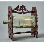 A VINTAGE SHIP IN A BOTTLE, THREE MASTED SCHOONER CONTAINED WITHIN A BOTTLE WITHIN A FRET CUT FRAME,