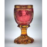 A BOHEMIAN RUBY AND AMBER CASED GLASS GOBLET, C1850, THE BOWL ENGRAVED WITH AN OVAL PANEL OF THE