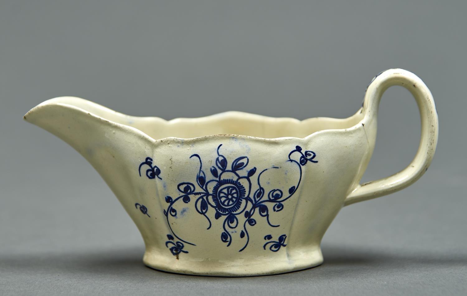 A CREAMWARE SAUCEBOAT, PERHAPS YORKSHIRE, C1790, PAINTED IN BLUE TO EITHER SIDE WITH A SIMPLE