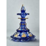 A BOHEMIAN BLUE CASED GLASS SCENT BOTTLE AND STOPPER, C1860, THE FACETS IN RAISED GILDING WITH