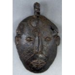 Tribal art. An African bronze face form ceremonial ladle, possibly 19th c, with elliptical slit