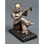 An Art Deco silvered and patinated metal and ivorine statuette of a pierrot playing the mandolin,