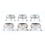 A set of six Scottish Victorian silver salt cellars, chased with rocaille, on hoof feet,