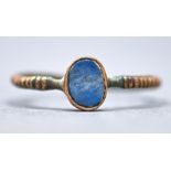 Antiquity. A Romano British bronze finger ring, second century AD, set with an oval blue stone,