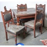An oak draw leaf dining table on turned legs and a set of four Edwardian carved oak dining chairs