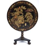 A Chinese black and gold lacquer table, late 19th c, the round tip-up top decorated with two figures