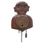 A German oxidised brass and carved and brown stained soft wood 'rocking eyes' figural wall