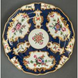 A Worcester scale blue ground plate, c1770, painted with flowers in gilt reserves and lightly