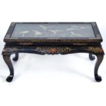 A reproduction black lacquer coffee table in Chinese style, the panelled top applied in relief