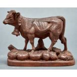 A well carved Swiss limewood model of a cow, early 20th c, naturalistic oblong base, 15.5cm h
