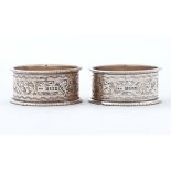 A pair of Edwardian silver napkin rings, engraved with a band of foliage, by John Rose, Birmingham