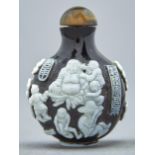 A Chinese cameo glass snuff bottle, 20th c, of intense ruby red glass overlaid in white and carved