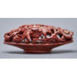 A Chinese peach stone carving of a basket of flowers, 19th c, 48mm l Some accretion of dust and