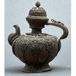 A Tibetan copper teapot and cover, 19th / early 20th c, applied with repousse strapwork and