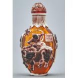 A Chinese triple overlay cameo glass snuff bottle, 20th c, in amber glass overlaid in white and