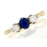 A sapphire and diamond ring, the cushion shaped sapphire flanked by round brilliant cut diamonds,