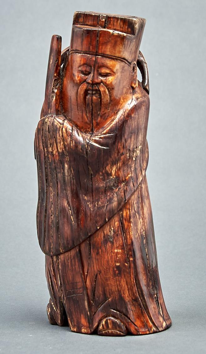 A Chinese stained ivory carving of an immortal, Qing dynasty, 19th c, 26cm h Old cracks and V shaped