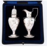 A George V silver sugar caster and cover and matching cream jug, applied with rococo borders, 14.5cm