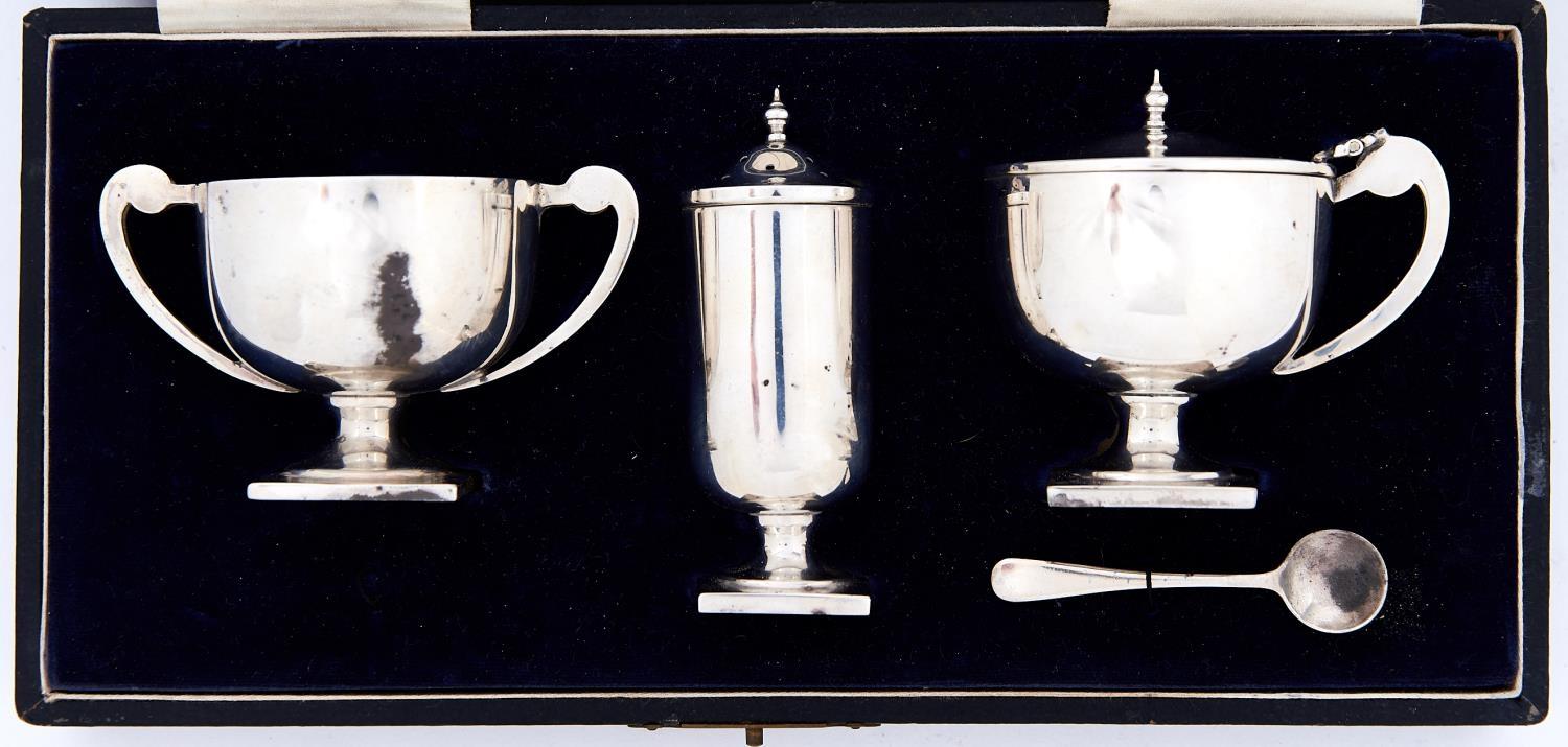 A George V silver trophy shaped condiment set, pepperette 82mm h, by William Adams Ltd, Birmingham