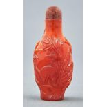 A Chinese amber snuff bottle, 20th c, carved with a bird and plants, 64mm, aventurine stopper Good