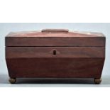 A Regency mahogany sarcophagus shaped tea caddy, the top with central raised rectangular tablet, the