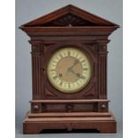 A late Victorian oak cased mantel clock, c1890, the flared architectural pediment with radiating