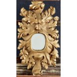 A carved oak mirror in the form of a grotesque mask, perhaps representing the green man, 19th c,