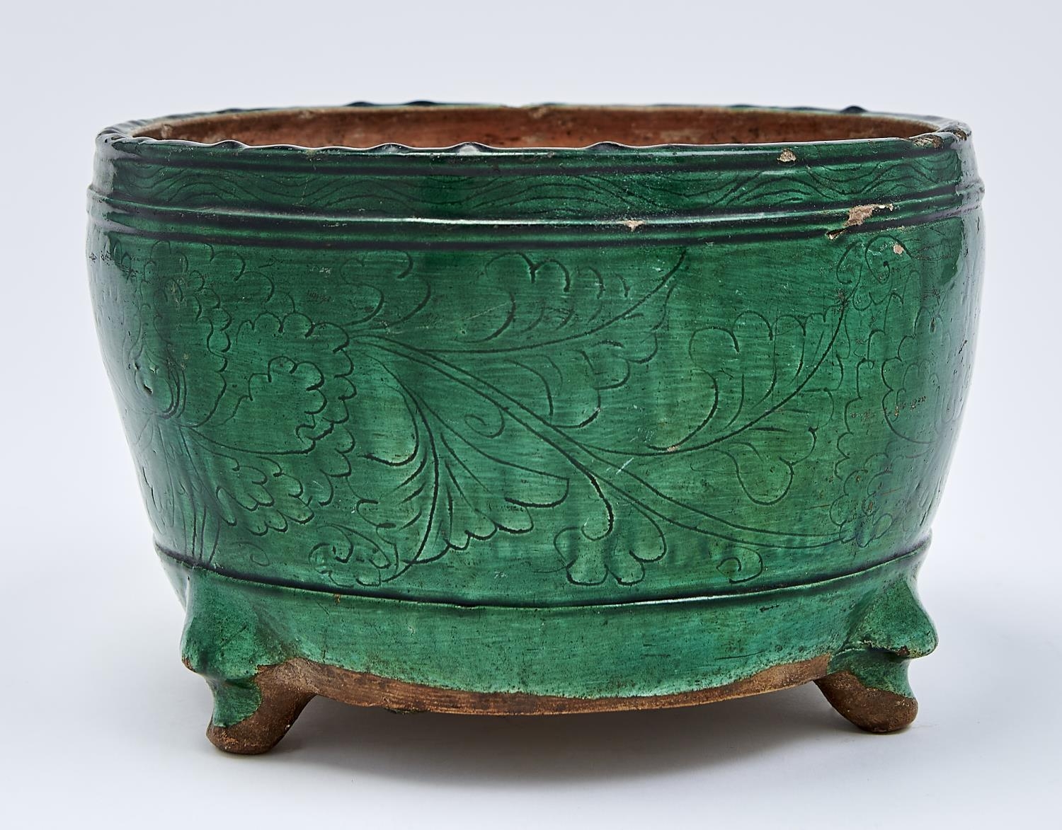 A Chinese green glazed biscuit tripod censer, Ming dynasty, early 17th c, the rounded sides
