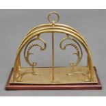 A brass magazine rack, early 20th c, on associated mahogany base, 33cm h One or two minor dents