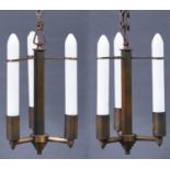 A pair of Art Deco brass hanging lights, c1950, retaining the original opal candle form light bulbs,