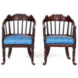 A pair of Victorian mahogany bergeres, c1850, the back hoop on bobbin turned spindles and crested by