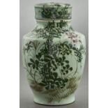 A Chinese shouldered oviform celadon ground jar and cover, 20th c, painted with flowering plants,