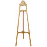 A French giltwood and composition salon easel, early 20th c, in Louis XVI style, crested by a bow