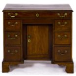 A George III mahogany kneehole desk or dressing table, c1780, with brass handles on bracket feet,
