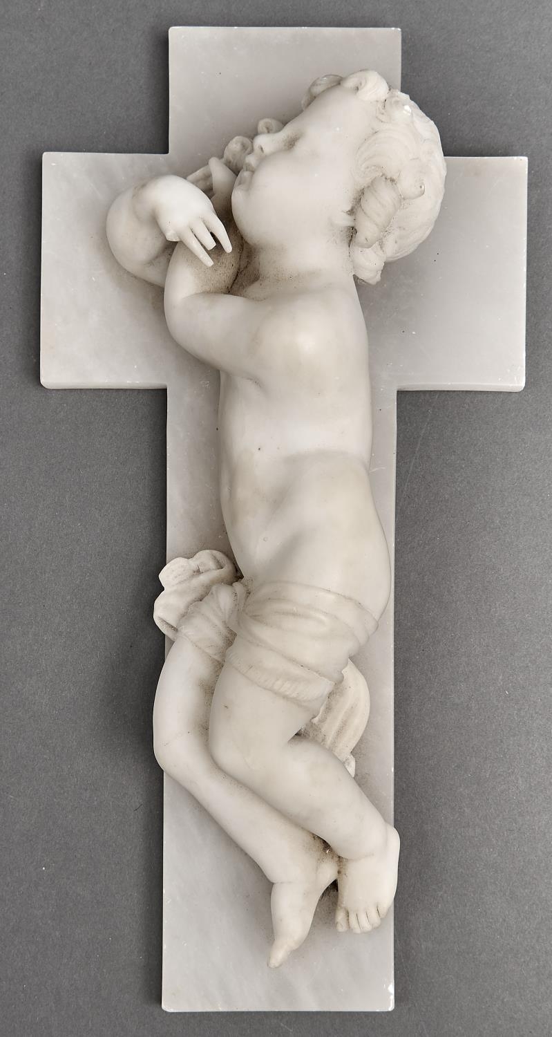 An Italian alabaster carving of a cherub and crucifix, the reverse with trade label for Giuseppe