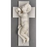 An Italian alabaster carving of a cherub and crucifix, the reverse with trade label for Giuseppe