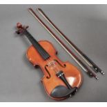 A violin,  unlabelled, length of back 35.5cm and two violin bows Violin - table cracked, back