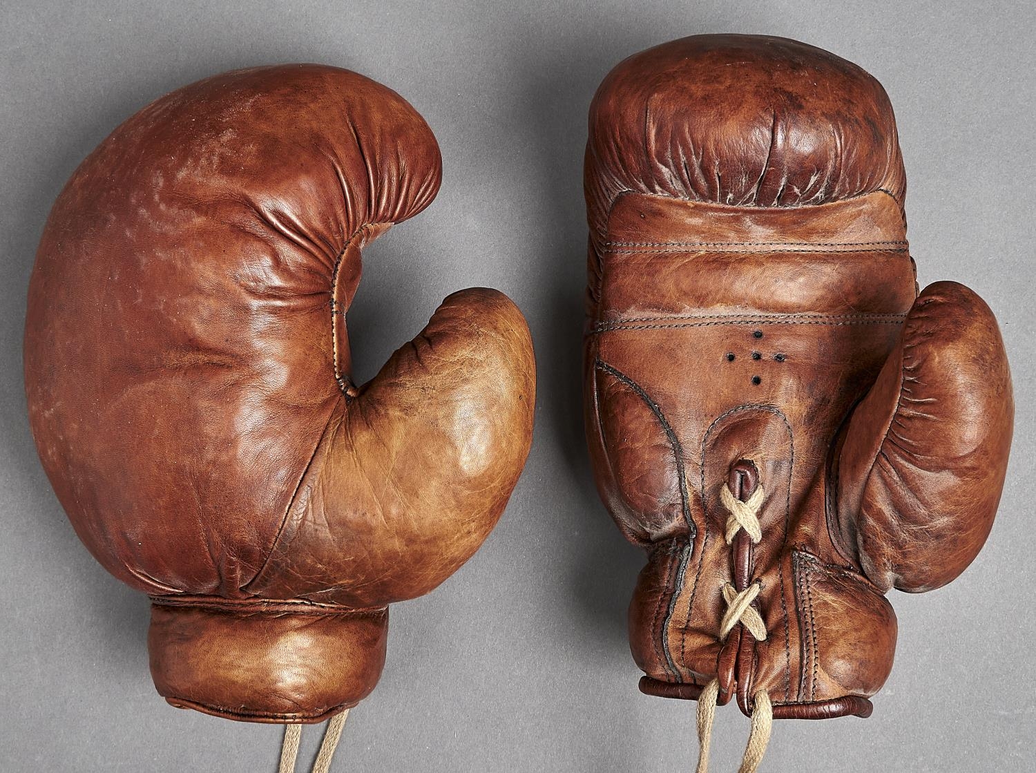 Boxing. An antique pair of leather boxing gloves, early 20th c In overall very good condition, no