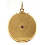 A gold locket set with a central ruby, marked 18ct, 4.6g