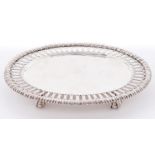 A Victorian oval silver card tray, with pierced border and cable rim, on four claw and ball feet,