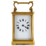 A French brass carriage timepiece, with swing carrying handle, white enamel dial with roman