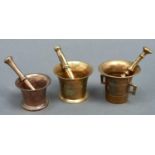 One  bell metal and two brass pestles and mortars, 19th c, mortars 9-11cm h All showing signs of