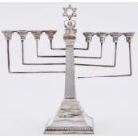 Judaica. A George V silver menorah, on flared square foot, 26.5cm h, by A Taiteldaun & Co, London