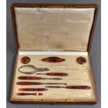 An Edwardian tortoiseshell handled manicure set, in silk and plush lined tooled leather fitted case,