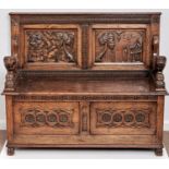 A reproduction oak monk's bench, c1950, the twin panelled back naively carved with figures, trees